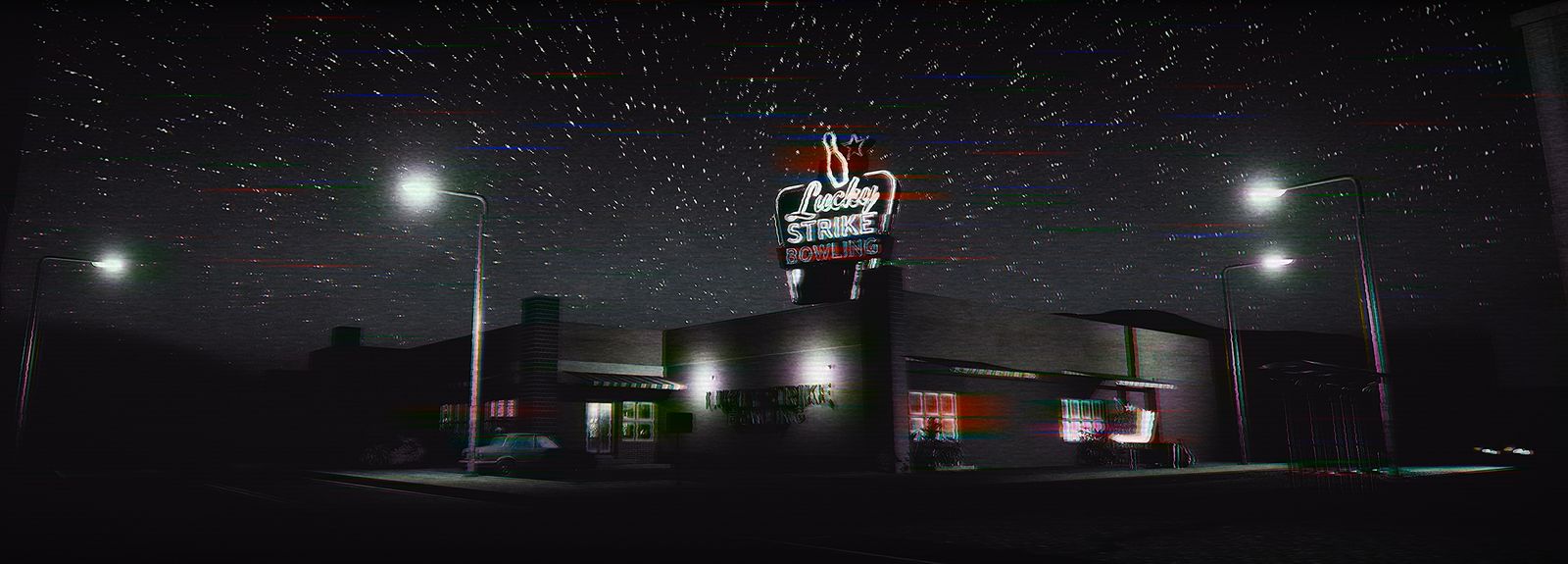 The bowling alley seen from the road at night, its neon sign lit above an empty car park