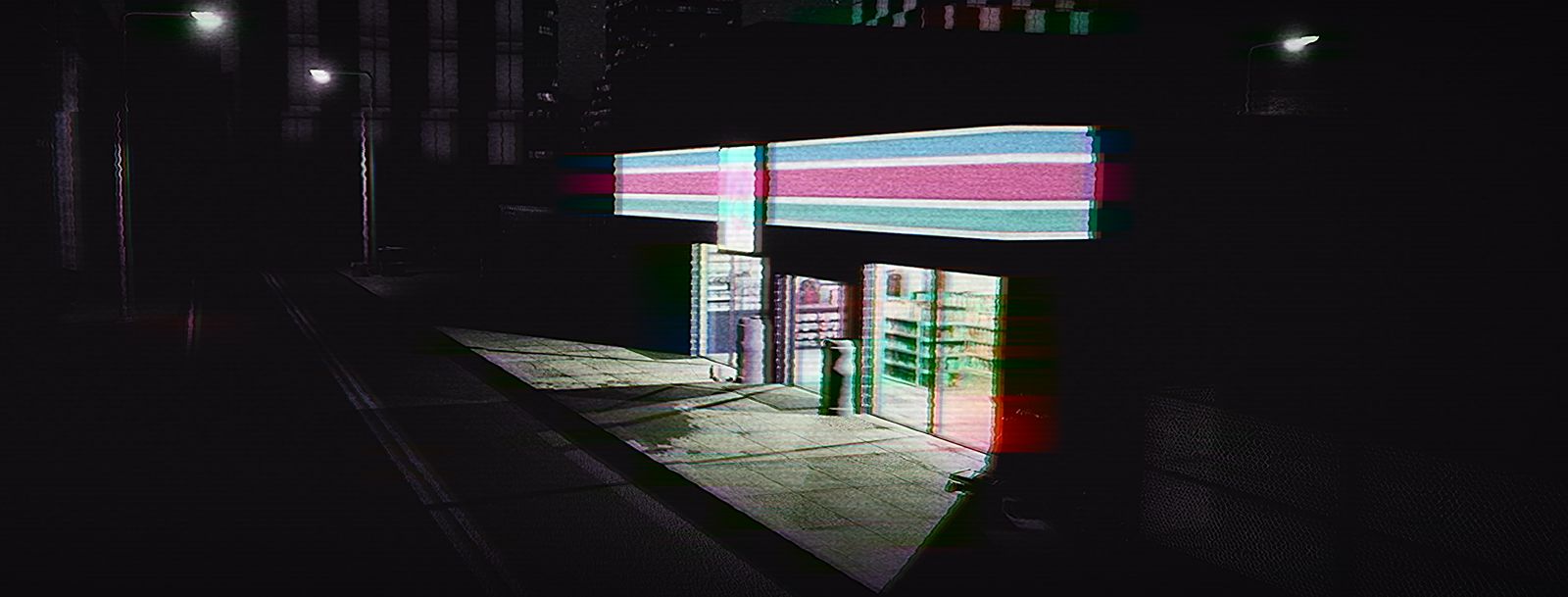 A convenience store front glowing across a wet pavement at night